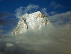 
The West Face of Gasherbrum IV shines at sunset from Goro II. The first ascent of Gasherbrum IV was made via the northeast ridge on August 6, 1958 by famed Italian mountaineer Walter Bonatti and Carlo Mauri on a strong Italian team led by legendary climber Riccardo Cassin. A desperate struggle between the mountain and ourselves, but we were all winners, and at 12.30 exactly the little pennants of Italy, Pakistan and the C.A.I. fluttered on the Summit itself. Fluttered  no, blew out in the howling gale. - Karakoram: The Ascent Of Gasherbrum IV by Fosco Maraini.
